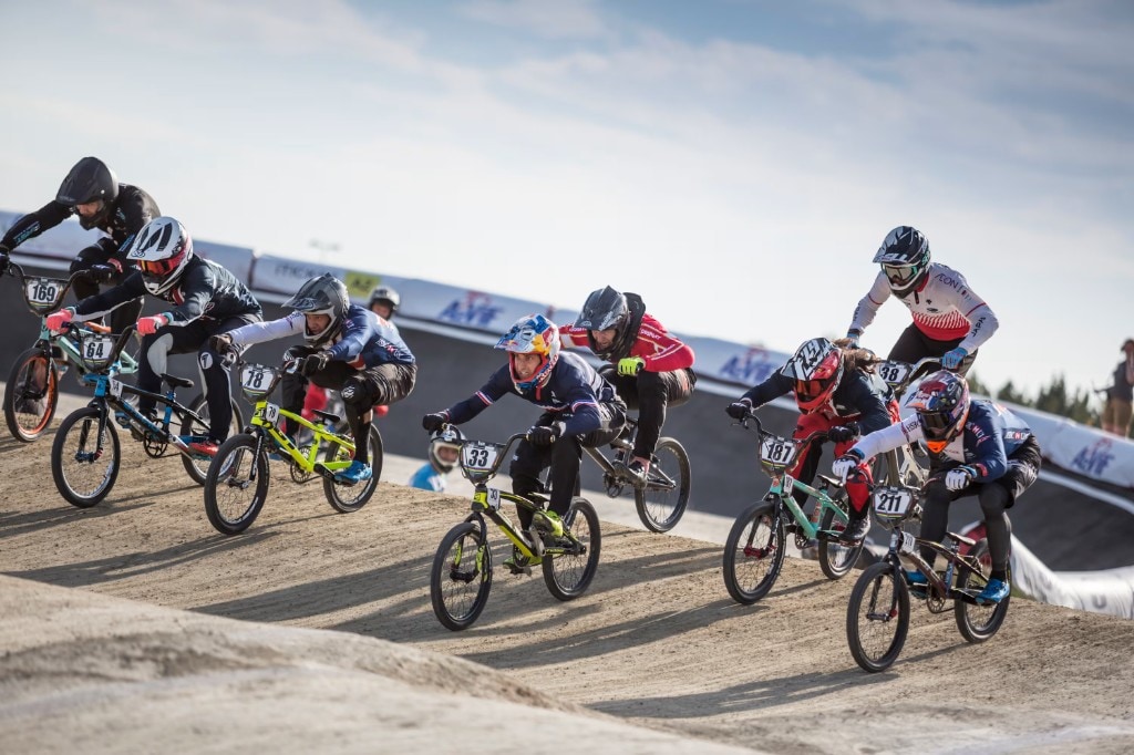 Corrida de BMX com vários competidores na pista ao ar livre